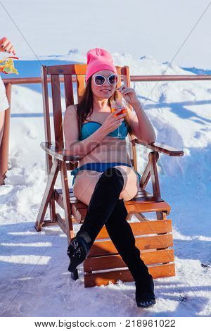 Novokuznetsk, Kemerovo region, Russia - 23 Feb, 2017 : White beaches of Siberia is an enterteiment activity where people playing beach games dressed in bikini in winter. Woman in bikini with cocktail