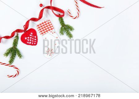Christmas holiday composition. Festive creative red pattern, xmas handmade decor holiday with ribbon, candy canes, gift, christmas tree and decorations on white background. Flat lay, top view