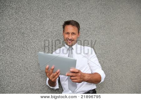 Usměvavý obchodník pomocí elektronických tabletu