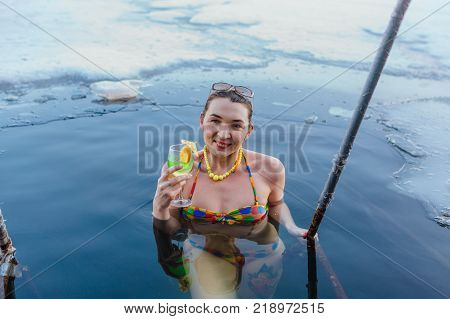 Novokuznetsk, Kemerovo region, Russia - 23 Feb, 2017 : White beaches of Siberia is an enterteiment activity where people playing beach games dressed in bikini in winter. Woman in an ice hole