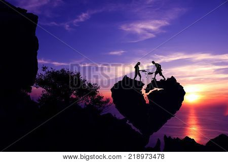Couple helping to shoveling stone for repair the broken heart shape rock on the mountain with purple sky sunset.Silhouette Valentine background concept.