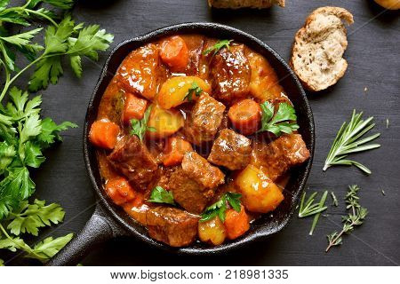 Beef stew goulash in cast iron pan. Top view flay lay