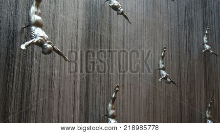 DUBAI, UNITED ARAB EMIRATES - MARCH 31st, 2014: Famous Waterfall in Dubai Mall world's largest shopping mall - 30m in diameter and 24 meters high with art fiberglass sculptures of human divers