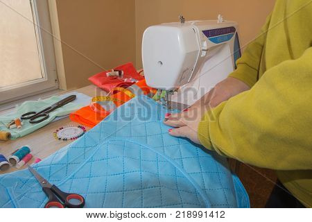 Tailor working at the studio. woman's hand sew cloth. Handmade. hands of female by needlework. Workplace of designer clothing close-up