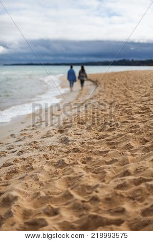 2 females selectively blurred on a beach walk