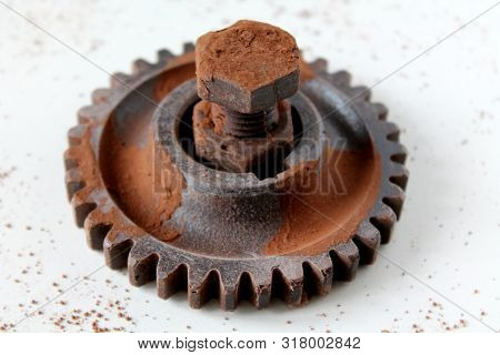 Rusty Bolt, Nut And Gear Wheel Made Of Chocolate Isolated On White Background. Chocolate Chip Scatte
