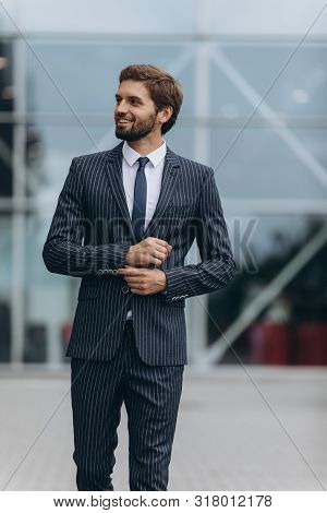 Confident Businessman. Confident Young Man In Full Suit Adjusting His Sleeve And Looking Away While 