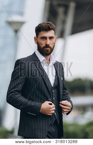 Confident Businessman. Confident Young Man In Full Suit Adjusting His Sleeve And Looking Away While 