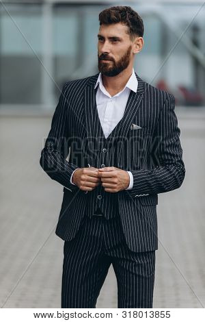 Confident Businessman. Confident Young Man In Full Suit Adjusting His Sleeve And Looking Away While 