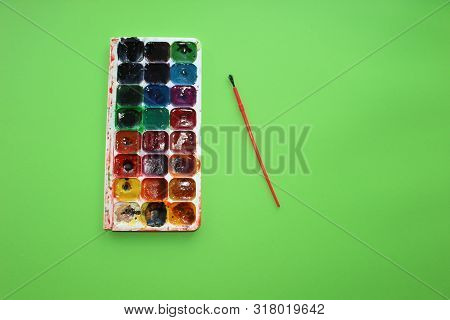 Brush, Paint On A Green Background. Watercolor And Colored Objects For School And Creativity.