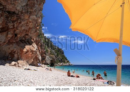 Konavle, Croatia - June 28, 2019: People Spend Vacation At Pasjaca Beach Below Cliffs In Konavle Reg