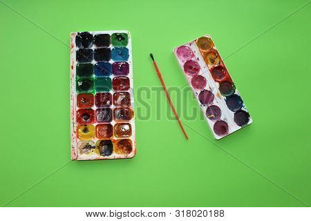 Brush, Paint On A Green Background. Watercolor And Colored Objects For School And Creativity.