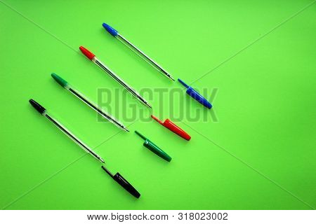 Colored Writing Pens. Colorful Items For School, Office On A Green Background.