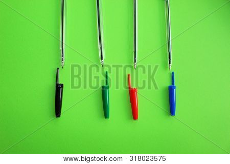 Colored Writing Pens. Colorful Items For School, Office On A Green Background.