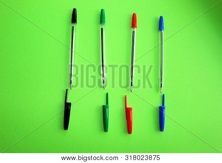 Colored Writing Pens. Colorful Items For School, Office On A Green Background.