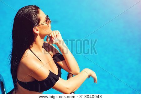 Elegant Sexy Woman In The Black Bikini On The Sun-tanned Slim And Shapely Body Is Posing Near The Sw