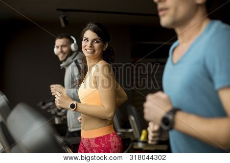 Young People Using Threadmill In Modern Gym