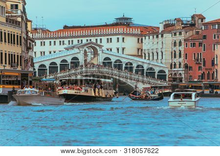 Venice, Italy - May 25, 2019: View Of Grand Canal Full Of Boats And Gandolas Rialto Bridge On Backgr