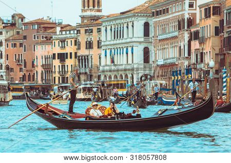 Venice, Italy - May 25, 2019: View Of Grand Canal Full Of Boats And Gandolas Rialto Bridge On Backgr