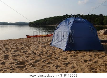 Blue Tent And Orange Kayak On A Deserted Sandy Beach Of A Lake Under The Evening Sky.lake La-peche Q