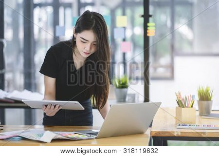 Young Asian Graphic Designer Working On Computor And Graphics Tablet In Her Working Space