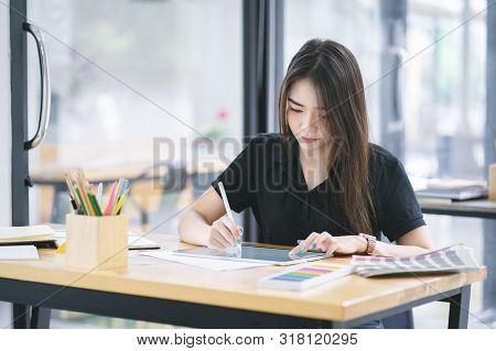 Young Asian Graphic Designer Working On Computor And Graphics Tablet In Her Working Space