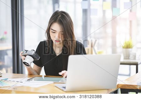 Young Asian Graphic Designer Working On Computor And Graphics Tablet In Her Working Space