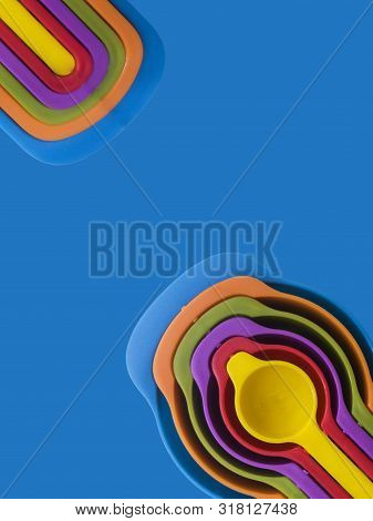 Measuring Spoon Set Made Of Colorful Plastic On A Blue Background, Kitchen Equipment. Group Of Steel
