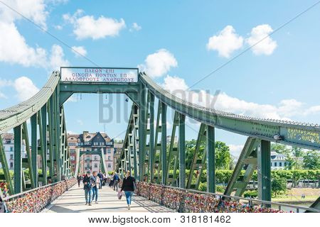 Frankfurt, Germany - June 12, 2019: River view of The Eiserner Steg.The Eiserner Steg is a pedestrian bridge in Frankfurt am Main built in 1868. City skyline in Frankfurt, Germany.