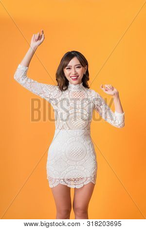 Young Pretty Asian Woman Smiling With Energetic Movement Studio Shot Isolatede On Colorful Yellow Ba