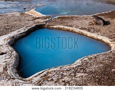 Blue Geothermal Pond At The Great Geysir, An Active Volcanic Geyser In Southwestern Iceland