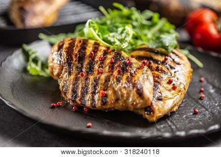 Chicken Breast Grilled With Spices Peper Salt Tomatoes And Arugula