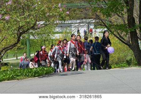 Pyongyang, North Korea - May 1, 2019: Squad Of Pioneer Girls Walking In The Taesongsan Funfair. Is A