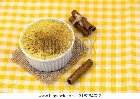 Dessert Of Curau. Brazilian Sweet Corn, Corn Mousse With Cinnamon On A Wooden Background. Typical Br