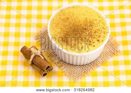 Dessert Of Curau. Brazilian Sweet Corn, Corn Mousse With Cinnamon On A Wooden Background. Typical Br