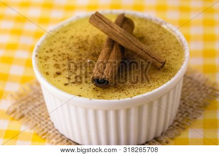 Dessert Of Curau. Brazilian Sweet Corn, Corn Mousse With Cinnamon On A Wooden Background. Typical Br
