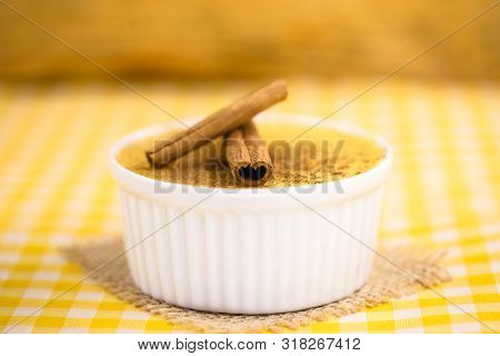 Dessert Of Curau. Brazilian Sweet Corn, Corn Mousse With Cinnamon On A Wooden Background. Typical Br