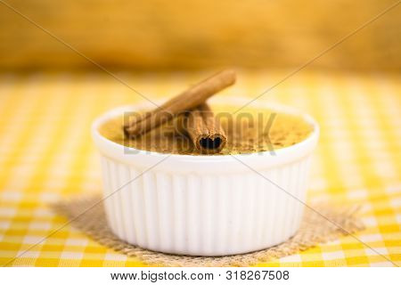 Dessert Of Curau. Brazilian Sweet Corn, Corn Mousse With Cinnamon On A Wooden Background. Typical Br