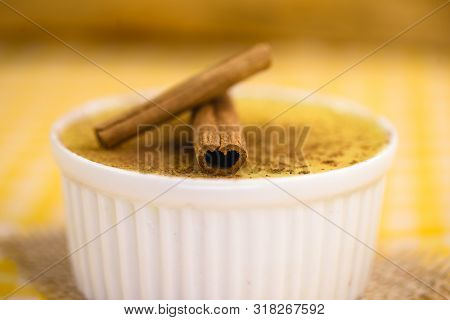 Dessert Of Curau. Brazilian Sweet Corn, Corn Mousse With Cinnamon On A Wooden Background. Typical Br