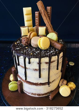 Birthday Or Wedding Cake, Layered, Drips Topped With Macaroons And Chocolate Pieces As An Indulgent 