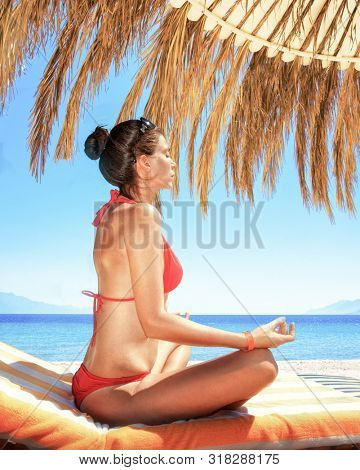 girl meditates on the hotel beach