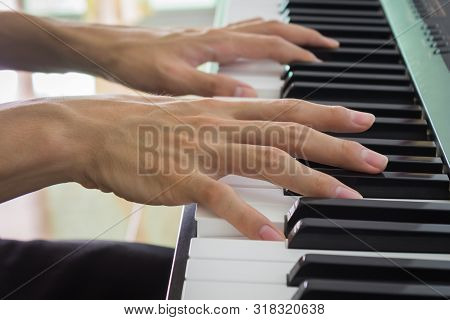 Hand Of Piano Player On White Keys And Black Keys Of Electric Piano In Zoom View