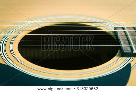 Sound Hole And Acoustic Guitar String And Pickguard And Fingerboard And Fret In Close Up View