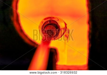Glass Blower Manufacturing Process, Working On A Bubble Of Melted Glass On A Rod By Heating It Up By