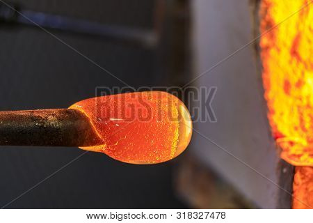 Glass Blower Manufacturing Process, Working On A Bubble Of Melted Glass On A Rod By Heating It Up By