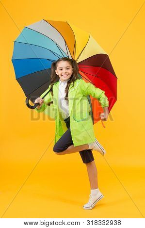 Simple Happiness. I Do Not Care. Carefree Schoolgirl Jumping With Umbrella Waterproof Rain Coat. Aut