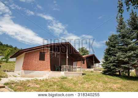 Wooden Bungalows And Garden In The Forest. Holiday Apartmens