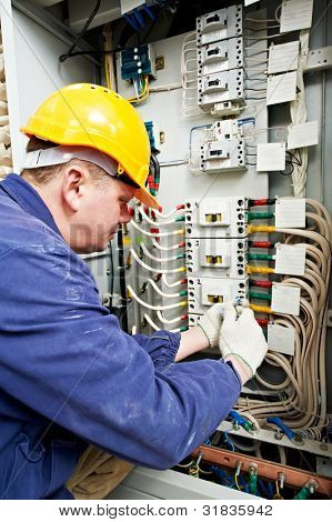 Jeden elektryk w pracy z klucza klucza dokręć śrubę w pole pomiarowe elektroniczne trójfazowe