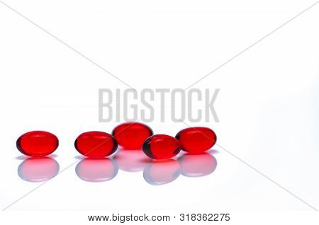 Red Soft Gel Capsule Pills Isolated On White Background. Pile Of Red Soft Gelatin Capsule. Vitamins 