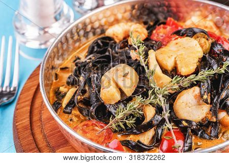Mediterranean Black Pasta With Shrimps, Tomatoes, Dumplings, Rosemary And Mushrooms